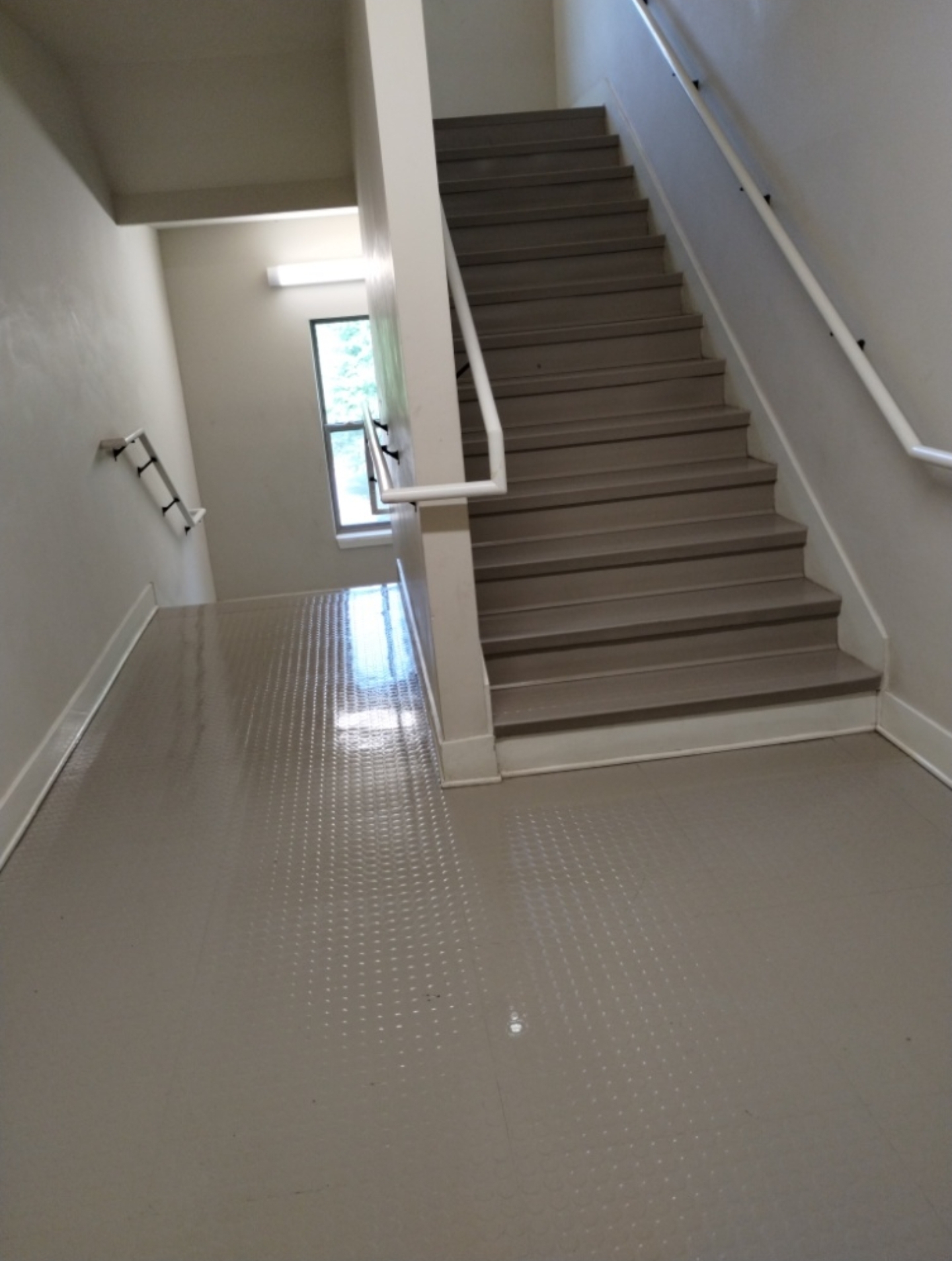 Spotless stairway landing with freshly cleaned tile floor and stairs
